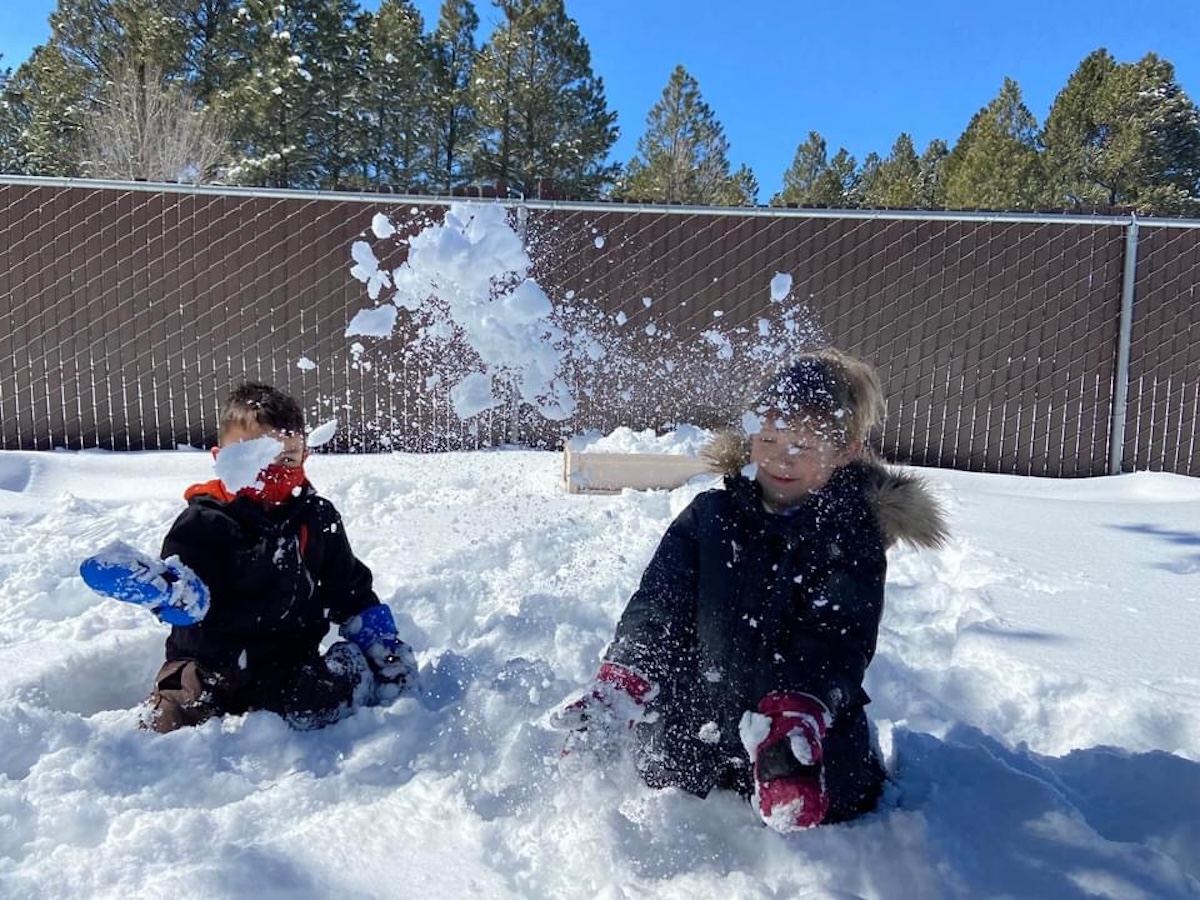 two kids playing the snow