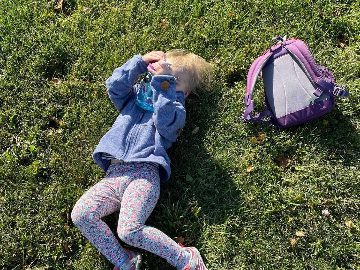 Best Hiking Backpacks for Kids - Horizontal 5 Little girl taking a break from her hike and from wearing the Deuter Pico