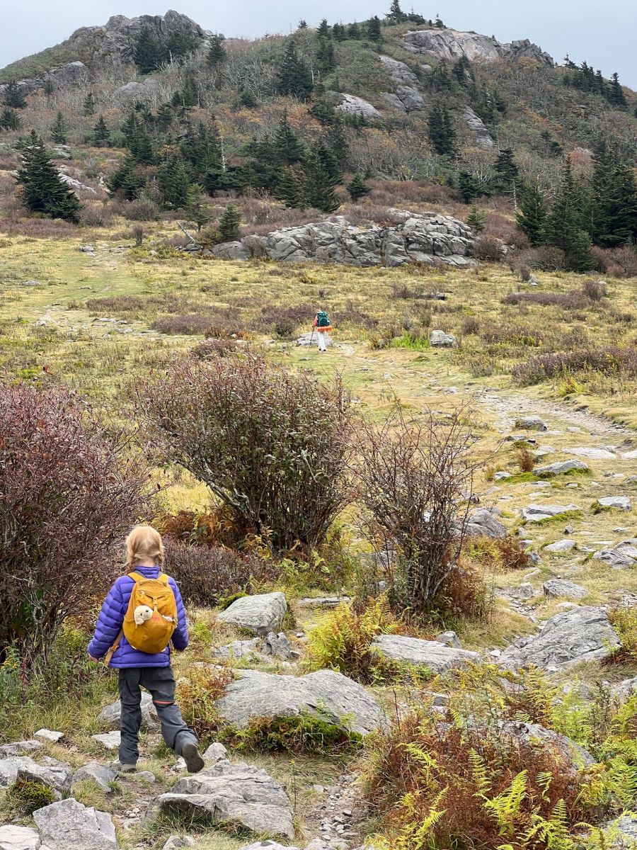 Little girls wearing a yellow tarn 12 hiking up a mountain