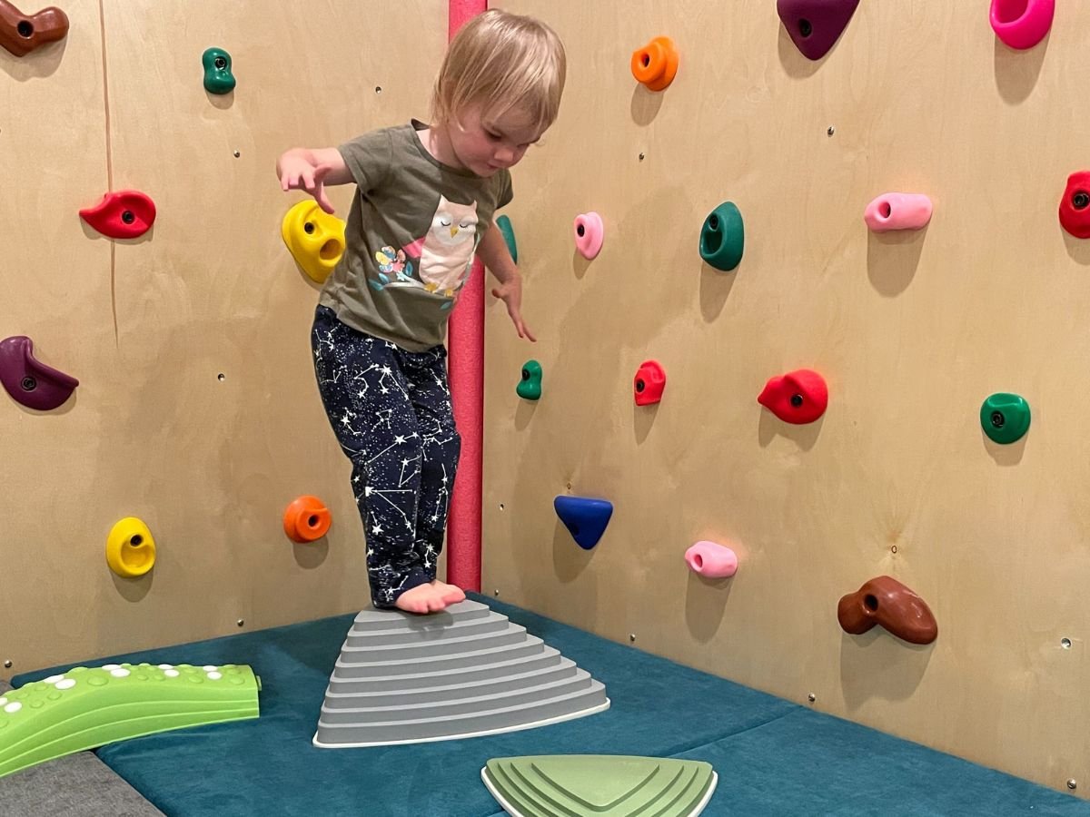 Best indoor active play gifts horizontal 2 Little girl is on a high step stone looking down at a low step stone