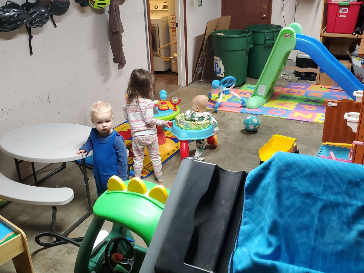 garage playroom with the little tikes slide and the bright starts around we go.