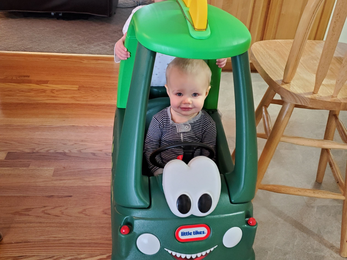 Best indoor active play gifts horizontal 4 Little boy sitting in a dino cozy coupe.