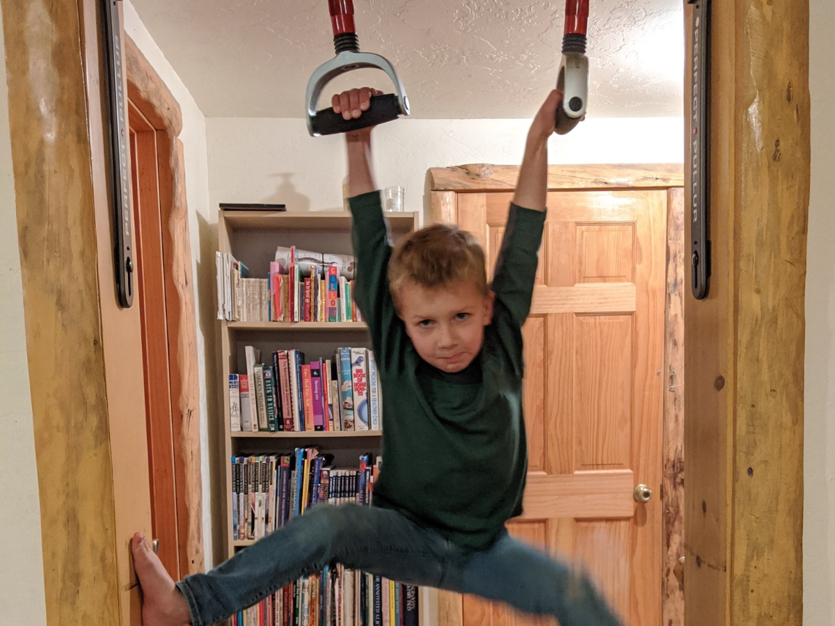 Best indoor active play gifts horizontal 7 Boy swinging on doorway gymnastics rings