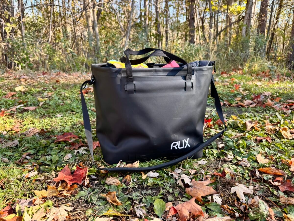 IMG_1150 A black Rux waterproof tote sits on grass and leaves.