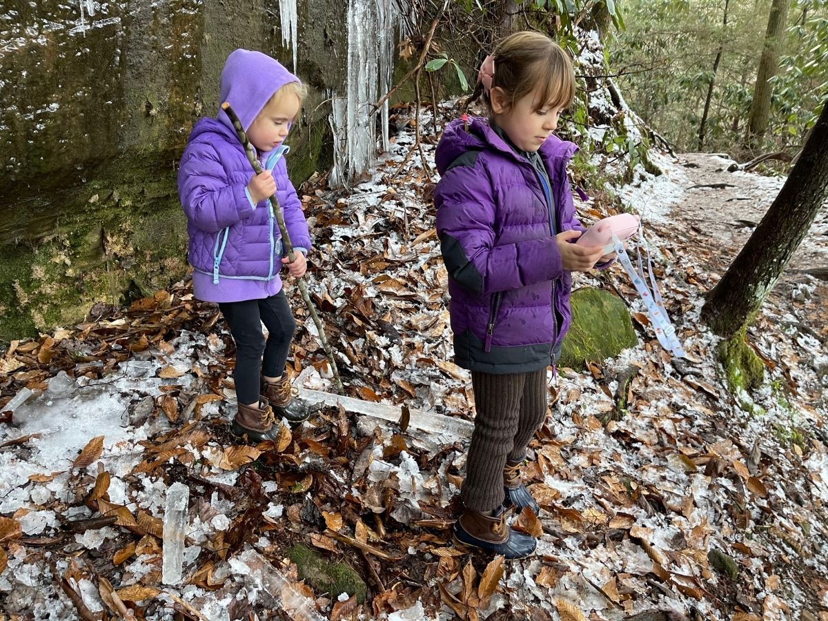 girls taking pictures outside on icy hike