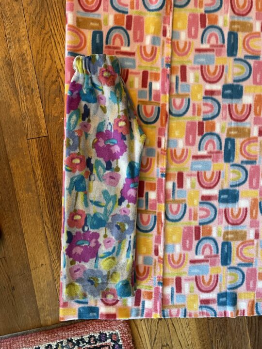 sample pants (folded in half) laid on top of folded fabric.