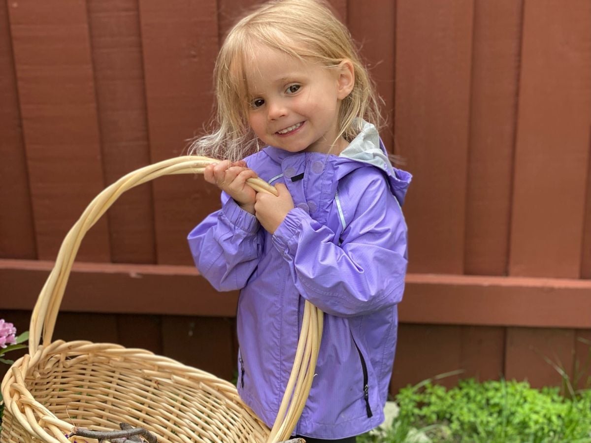 Easter Baskets for Outdoor Kids - Horizontal 1 Little girl holding up an easter basket and smiling