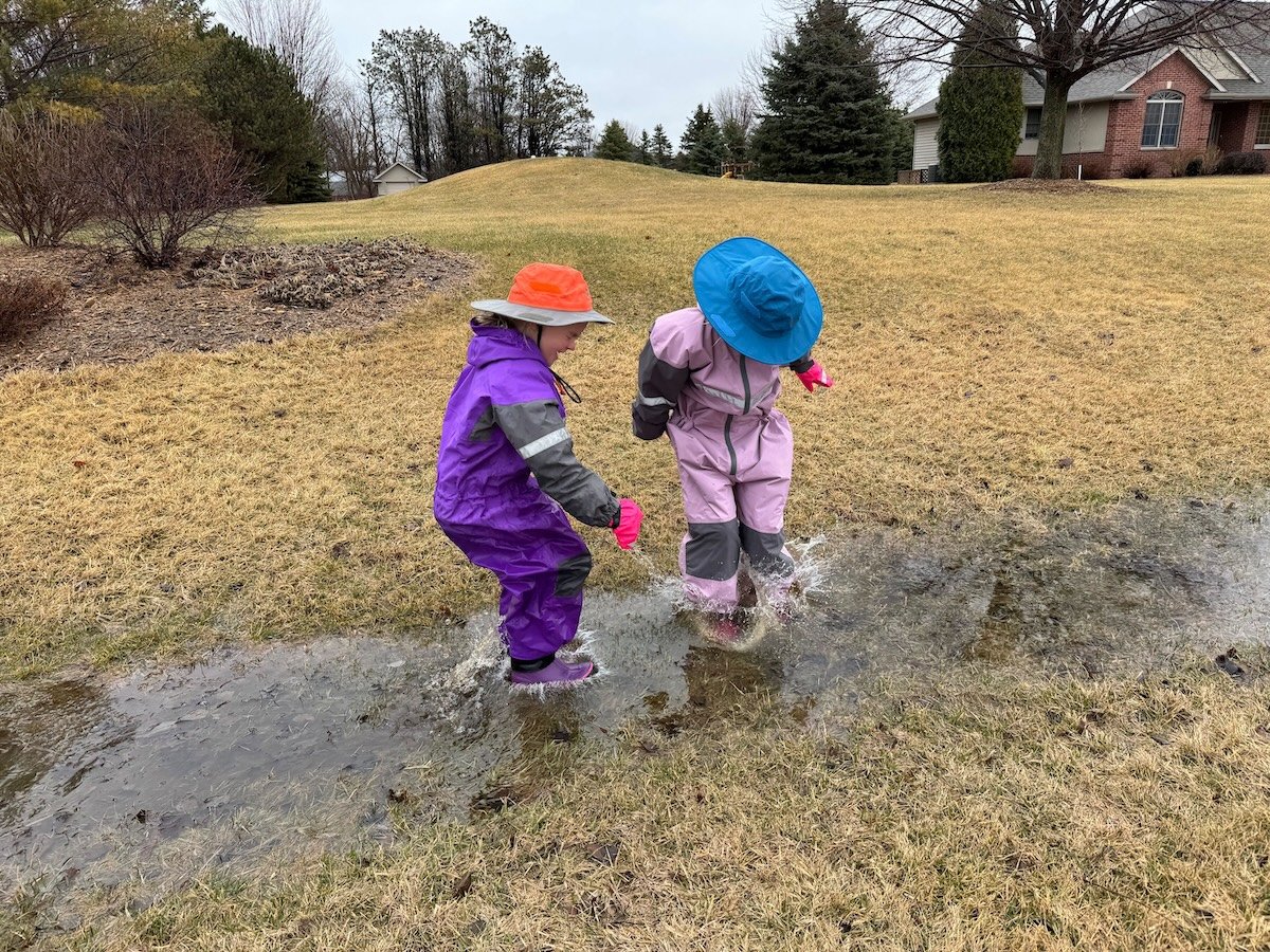bestraingearforkids9 two girls wearing rain hats playing in the rain