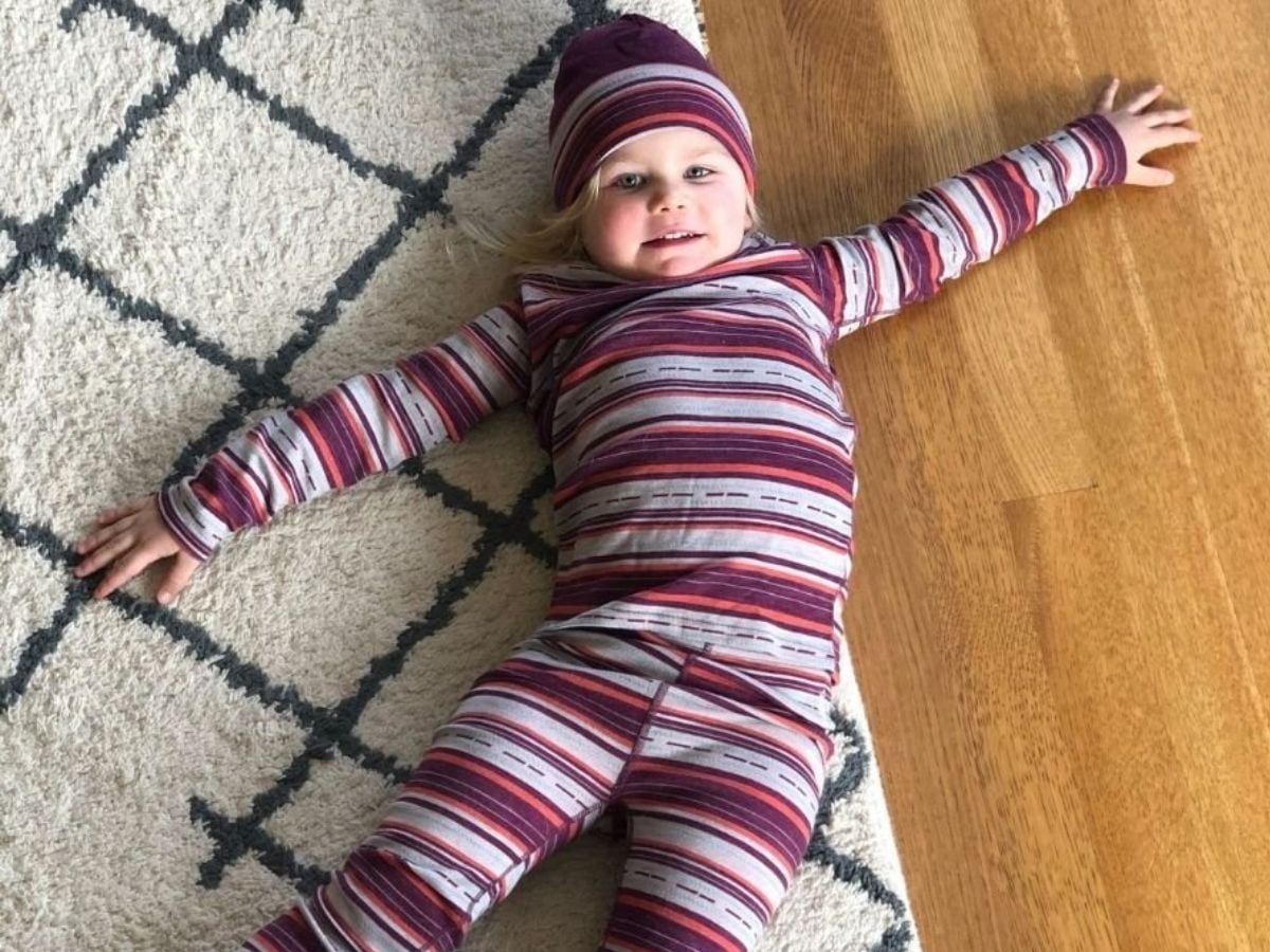 Best Base layers for kids Horizontal -4 Little girl laying on the floor wearing smart wool base layers