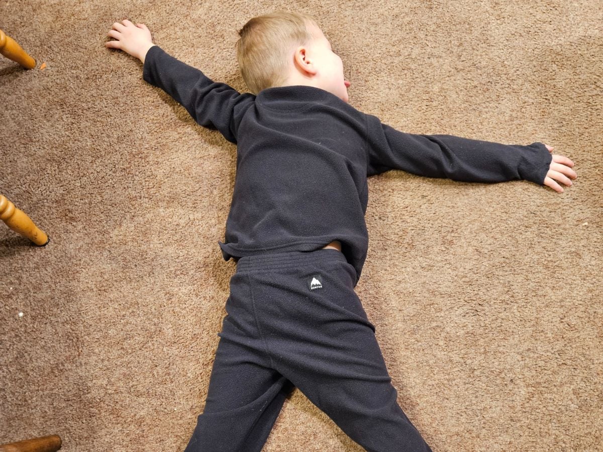 Best Base layers for kids Horizontal -7 Little boy plays dead while wearing burton base layers