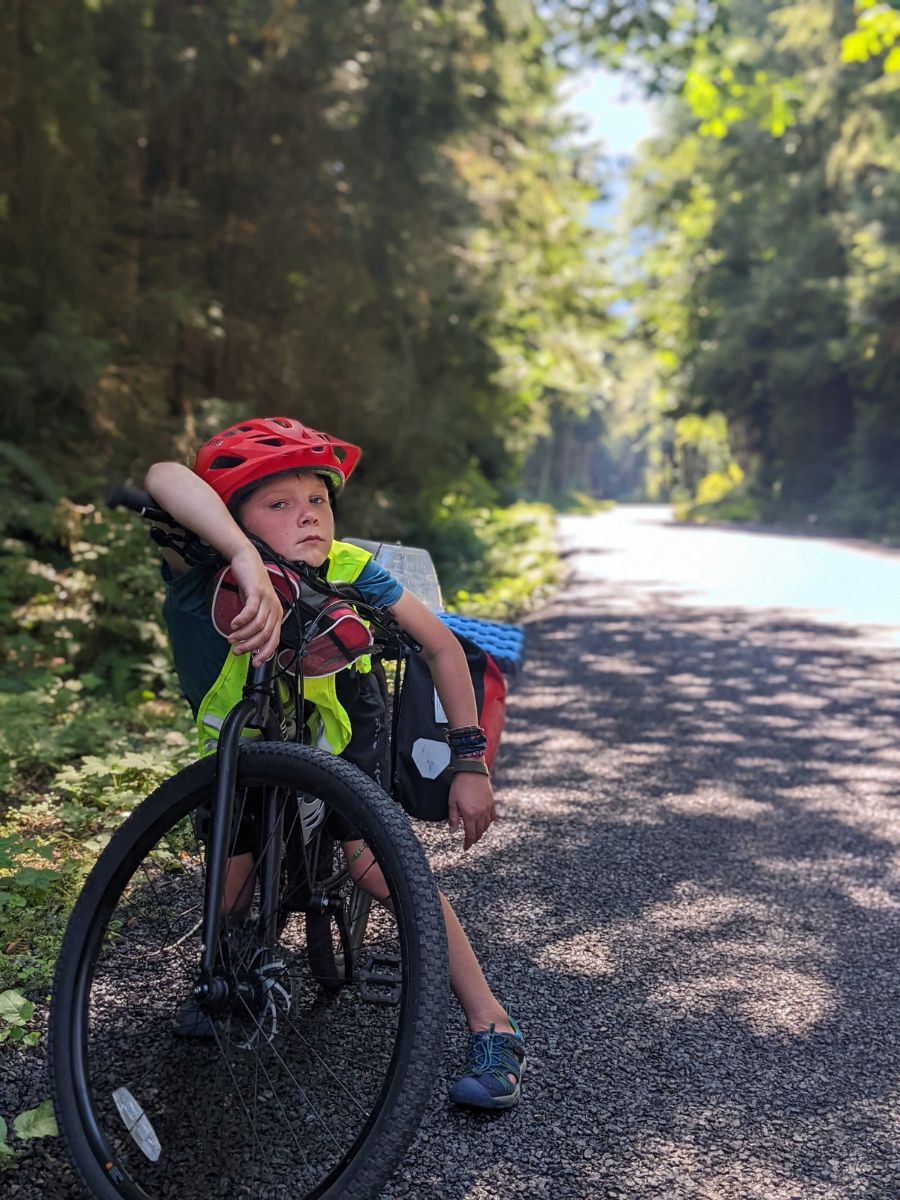 Grit3 A child rests on his bike while bike packing.