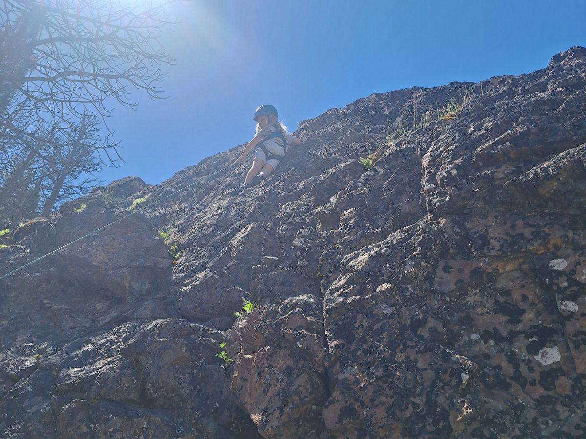 Grit7 A young child pauses to look down on a rock climbing pitch.