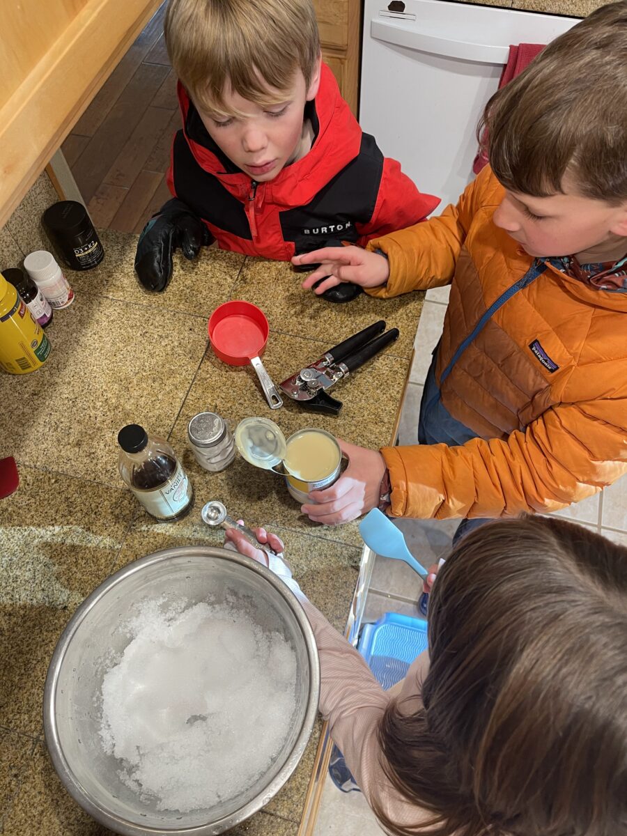Kids mixing ingredients into a bowl.