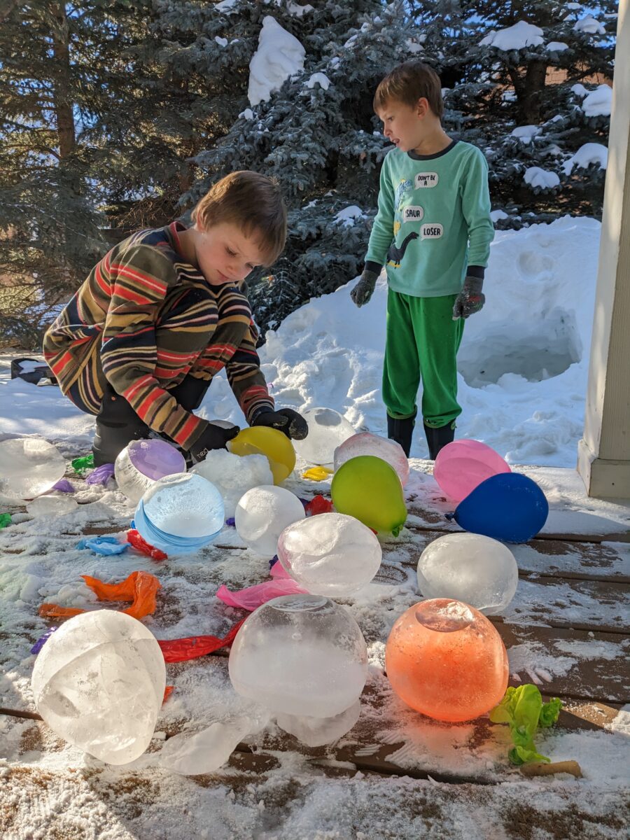 Boys on a porch tending to frozen ice balls.