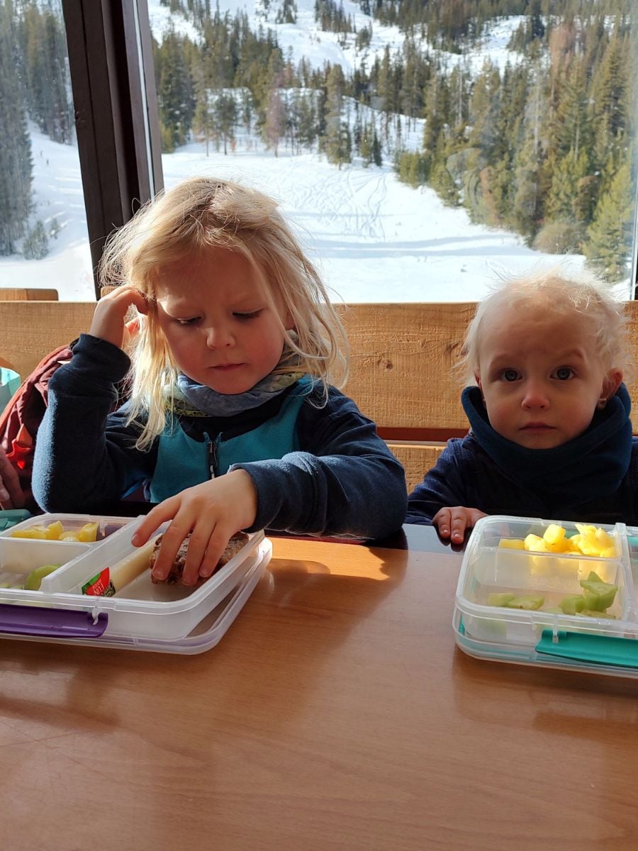 SkiFood5 Two kids eat lunch in a ski lodge.