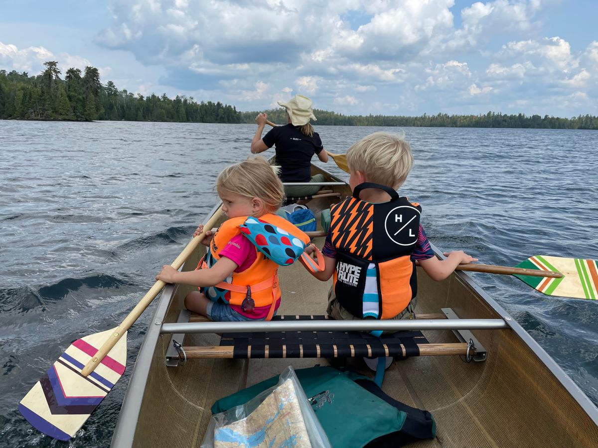 Woman in canoe with two kids