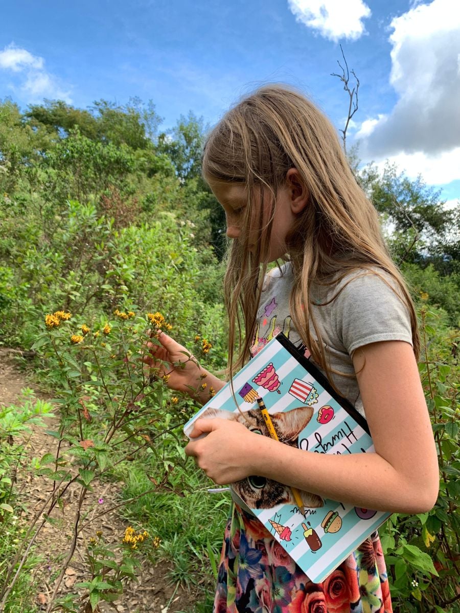 CitizenScienceforKids2 Girl holding notebook examining a flower