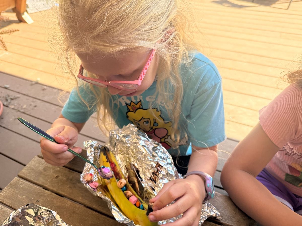 GF Meal Plan 3 Girl with glasses eating chocolates and marshmallows out of a banana wrapped in foil