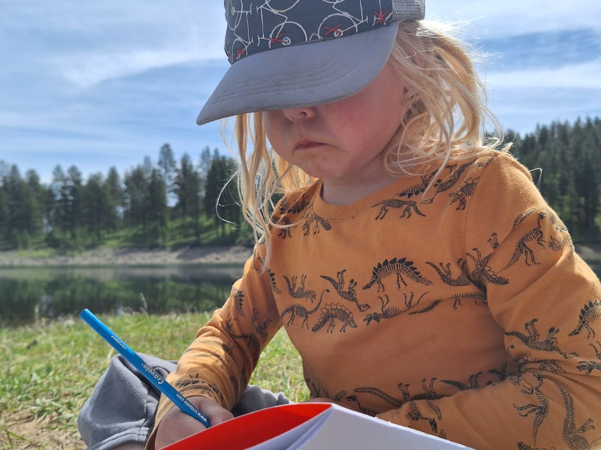 NtlParks7 A child draws in a journal outside.