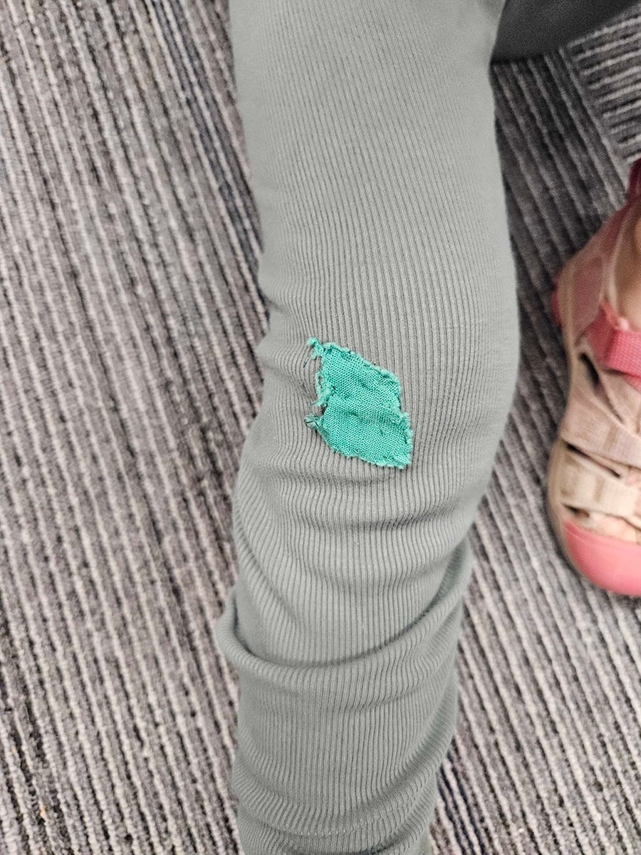 Leggings with a patch on the knee made of old clothes.