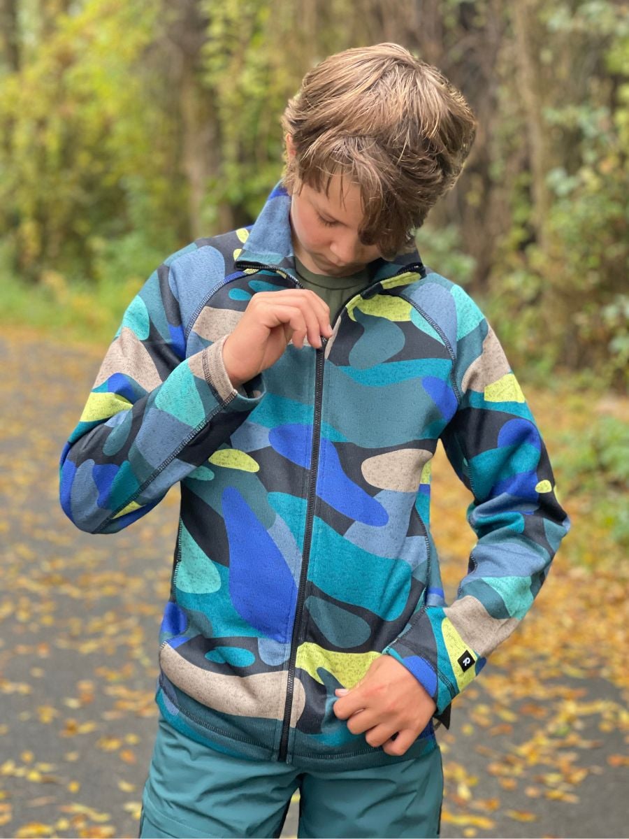 A boy zips up a Reima fleece.